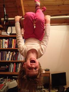 Anna hanging upside down from bar