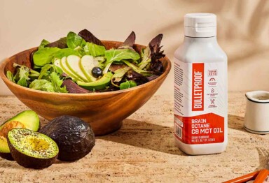 mct oil next to a bowl of lettuce and an avacado on the side