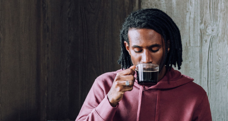 Man drinking a cup of black coffee.