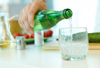 Person pouring mineral water into glass