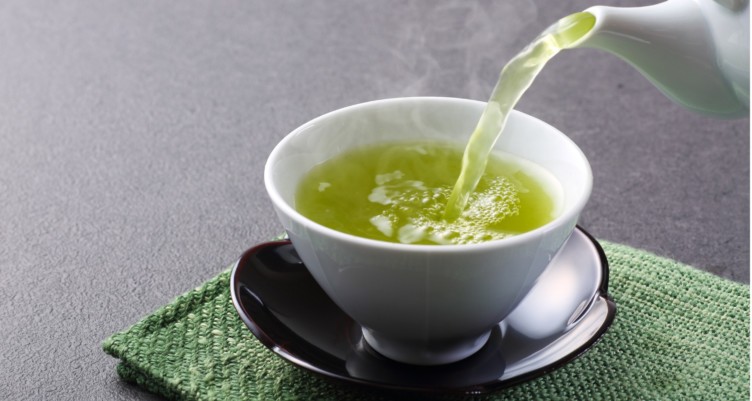 Pouring green tea into a mug