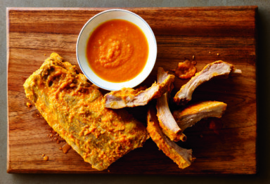 A rack of ribs with sauce on a cutting board