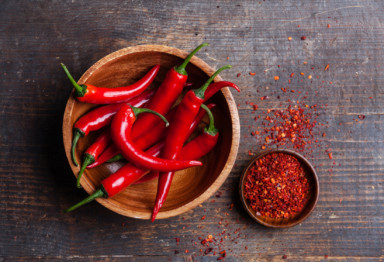 A bowl of hot peppers, and a small dish of dried pepper flakes