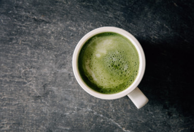 A mug of coffee with green foam