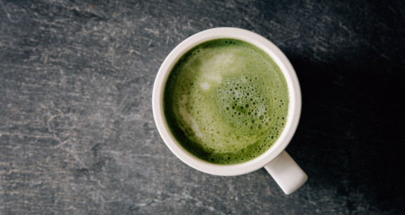 A mug of coffee with green foam