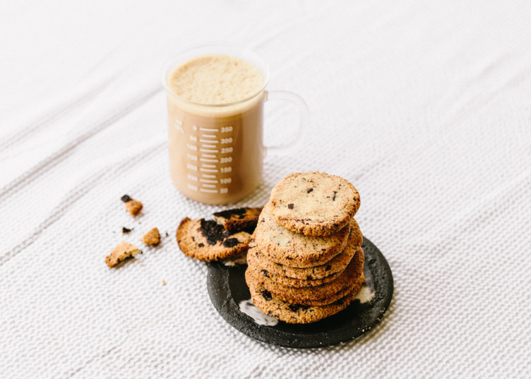 stack of keto cookies next to a coffee