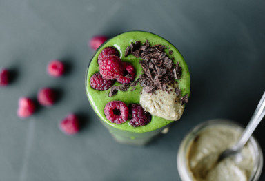A green smoothie with berries on top