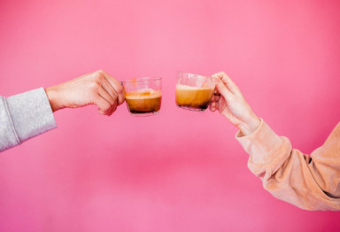 Two arms holding up cups of coffee