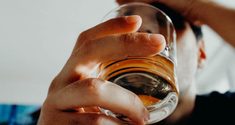 Person holding glass of alcohol