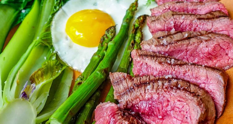 Sliced steak with asparagus and egg