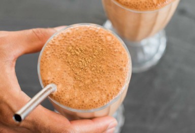 Chocolate collagen milkshake in glass with metal straw