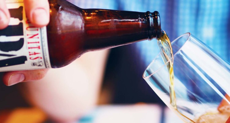 Hand pouring beer into cup