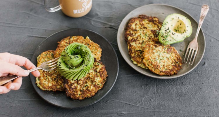 grey plate with fritters and cut avocado