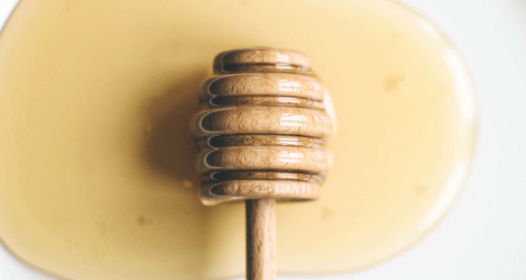 Honey stirrer in puddle of honey