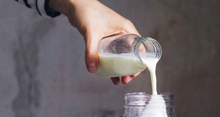 Person pouring from jar of milk