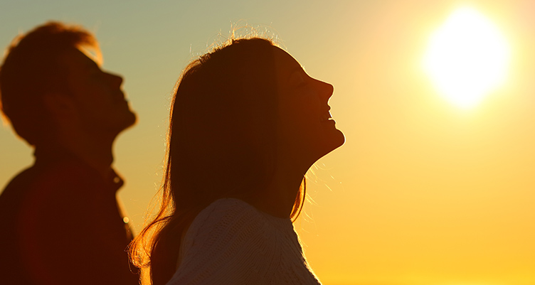 Man and woman standing outside in the sun