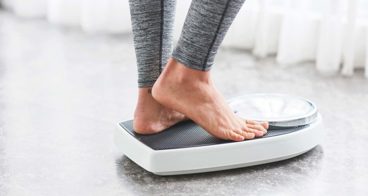 Feet of person stepping on scale