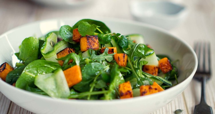 Bowl of salad greens and sweet potatoes