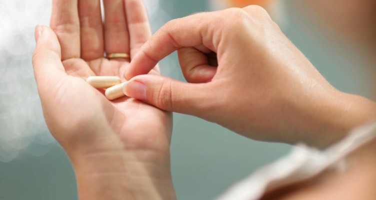 Person putting pill in palm