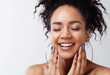 Smiling woman with hands on her face