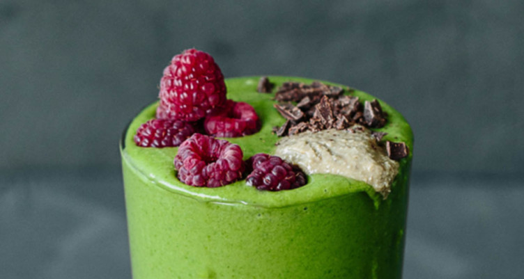 Green smoothie topped with berries