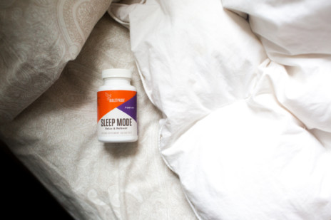 Bottle of Bulletproof Sleep Mode on white bed
