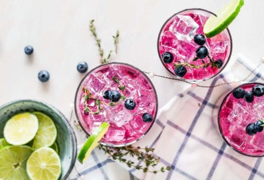Pink beverages with berries and limes