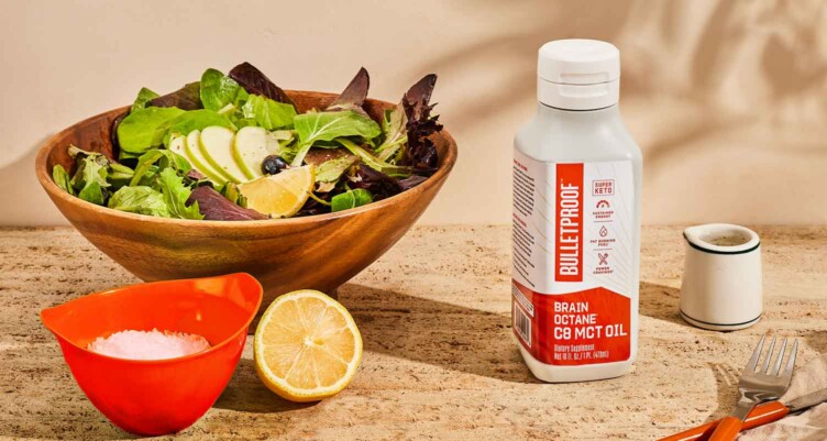 Brain Octane Oil sitting next to bowl of salad