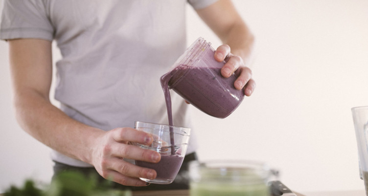 Man pouring smoothie into glass