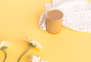 Cup of Bulletproof Coffee on yellow background