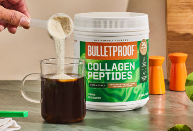 hand pours a scoop of unflavored collagen peptides into a clear mug of coffee
