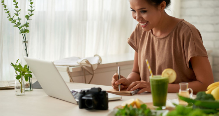 Woman writing in notebook at table