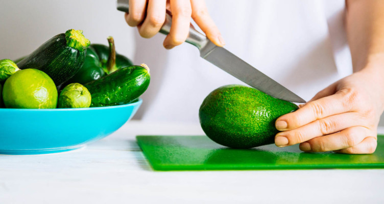 Person slicing avocado