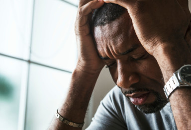 Closeup of man looking stressed out with his head in hands