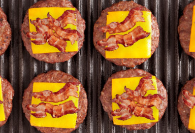 Burgers with cheese and bacon on grill