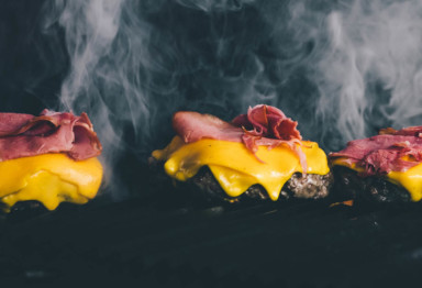 Bacon cheeseburgers on grill