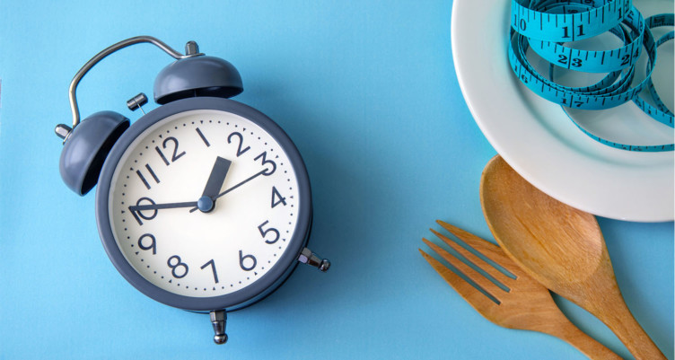 Alarm clock and plate on blue background