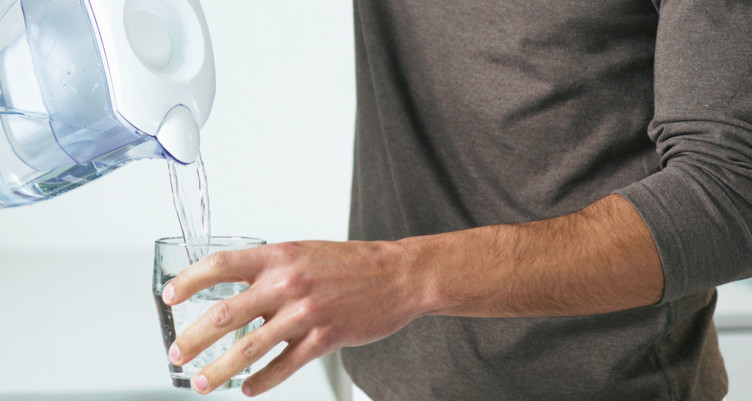 Person pouring water into glass