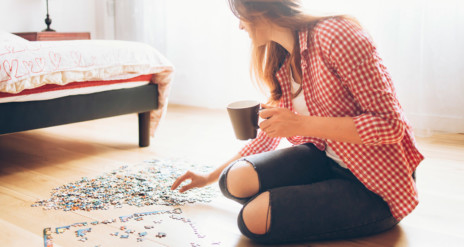 床でパズルを完成させる女性