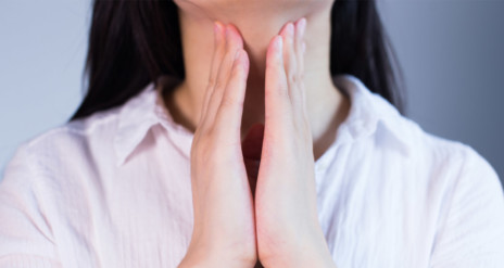 Femme avec les mains sur le cou