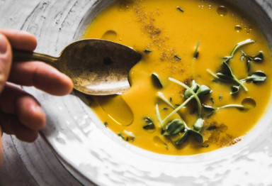 Roasted butternut squash soup with stirring spoon