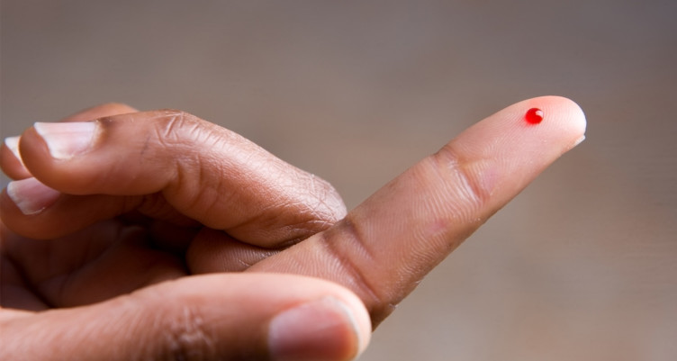 Drop of blood on fingertip