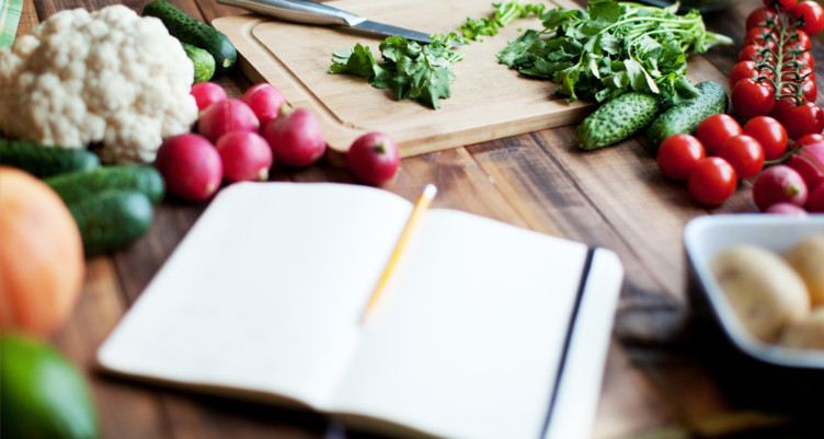 Notebook open next to produce on table