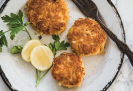 Crab cakes on white plate with parsley and lemon slices