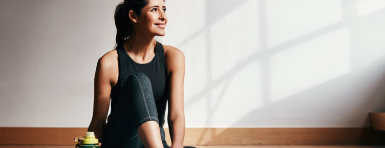 Woman wearing black workout clothes staring out window