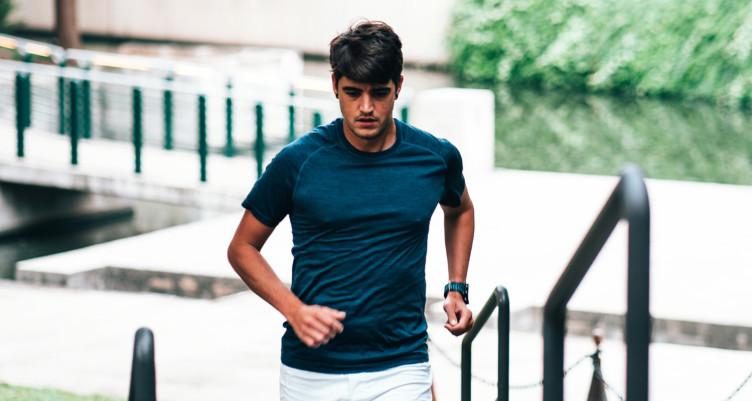 Man wearing blue shirt jogging outside