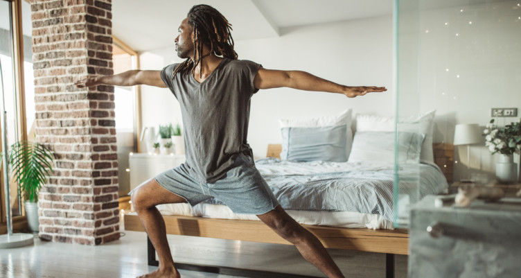 Posa di yoga della tenuta dell'uomo