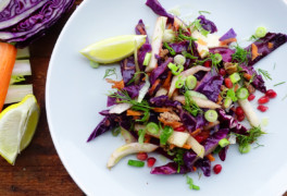 Colorful white plate of keto slaw with lemon wedges