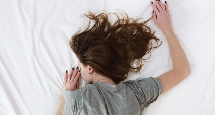 Woman sleeping face-down on bed
