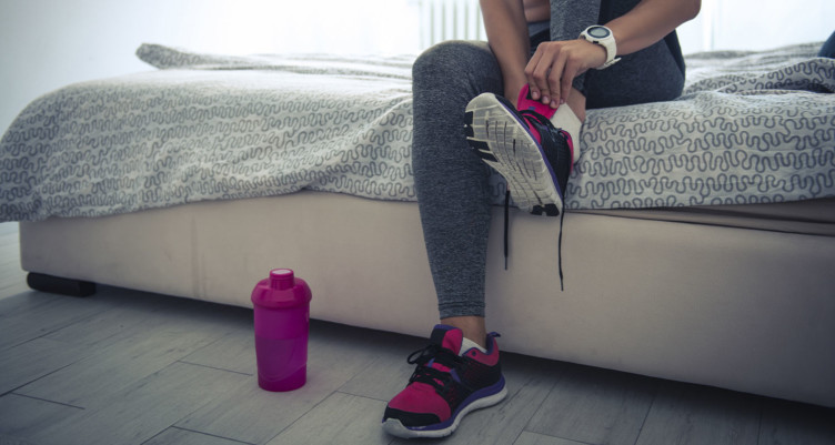 Woman lacing up running shoes